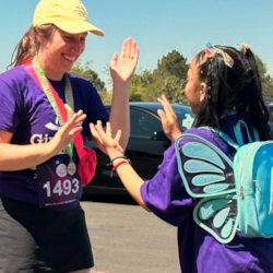 Girls on the Run coach and participant high-five